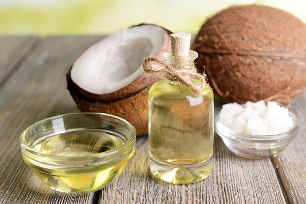 Coconuts and coconut oil on a wooden table outside